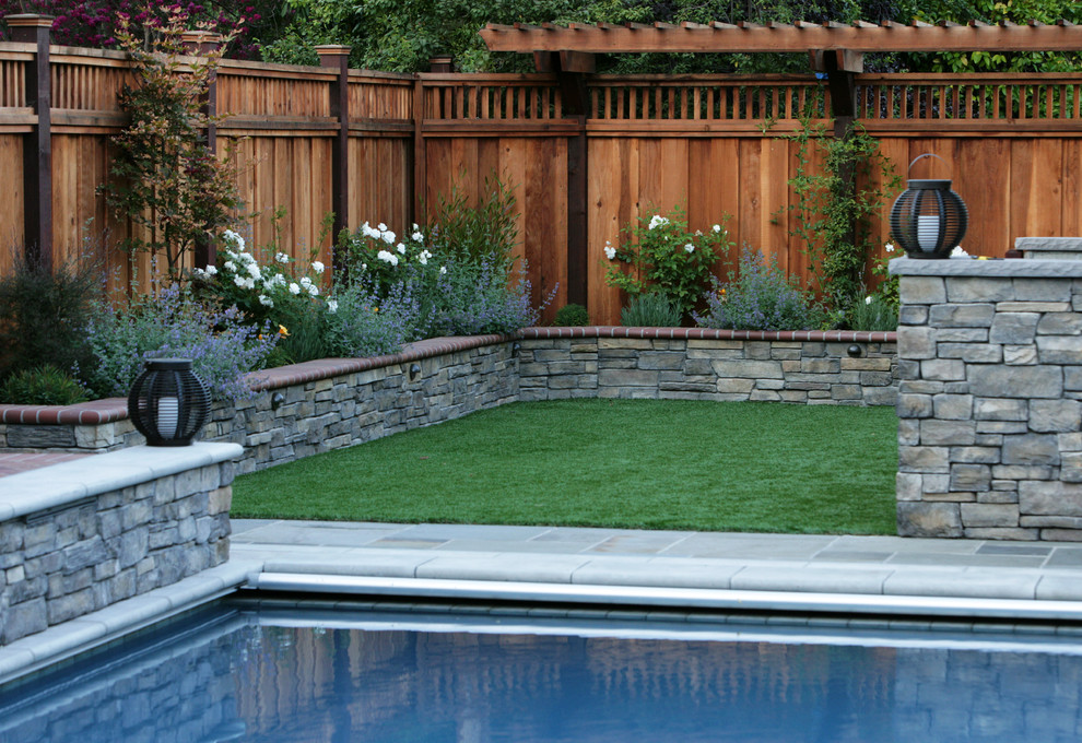 Immagine di una grande piscina monocorsia chic rettangolare dietro casa con pavimentazioni in pietra naturale