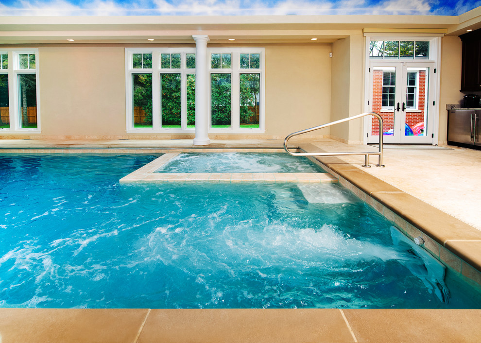 Idées déco pour une piscine intérieure classique de taille moyenne et rectangle avec des pavés en pierre naturelle et un bain bouillonnant.