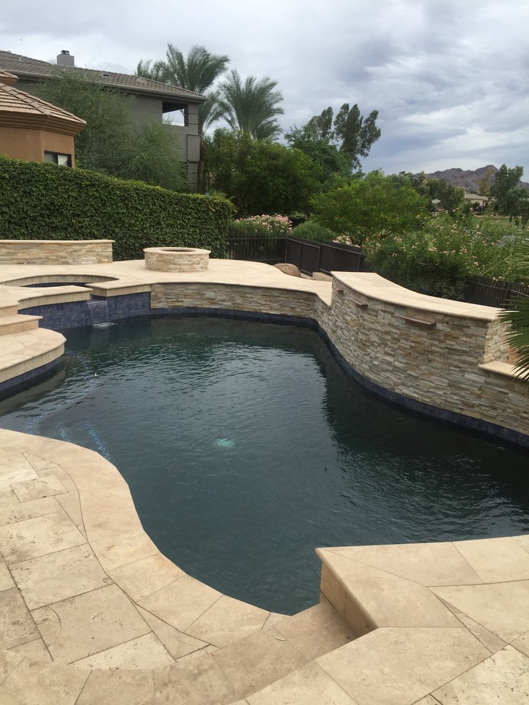 Inspiration för en liten funkis anpassad pool på baksidan av huset, med en fontän och naturstensplattor