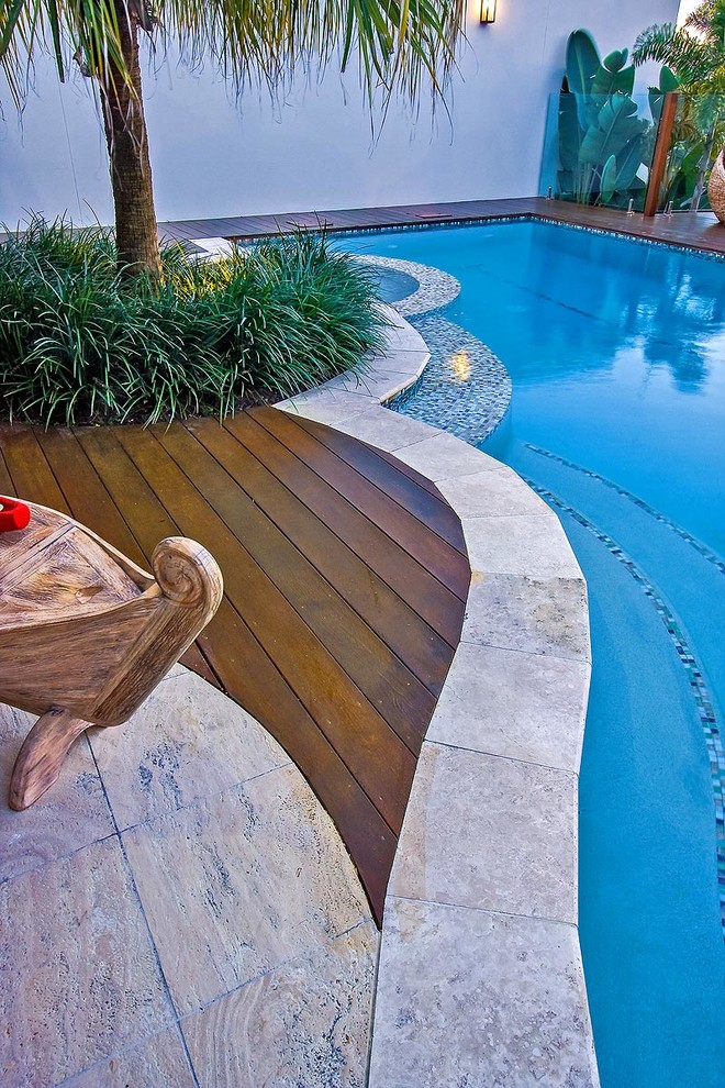 Inspiration for a mid-sized tropical backyard stone and custom-shaped infinity pool house remodel in Brisbane