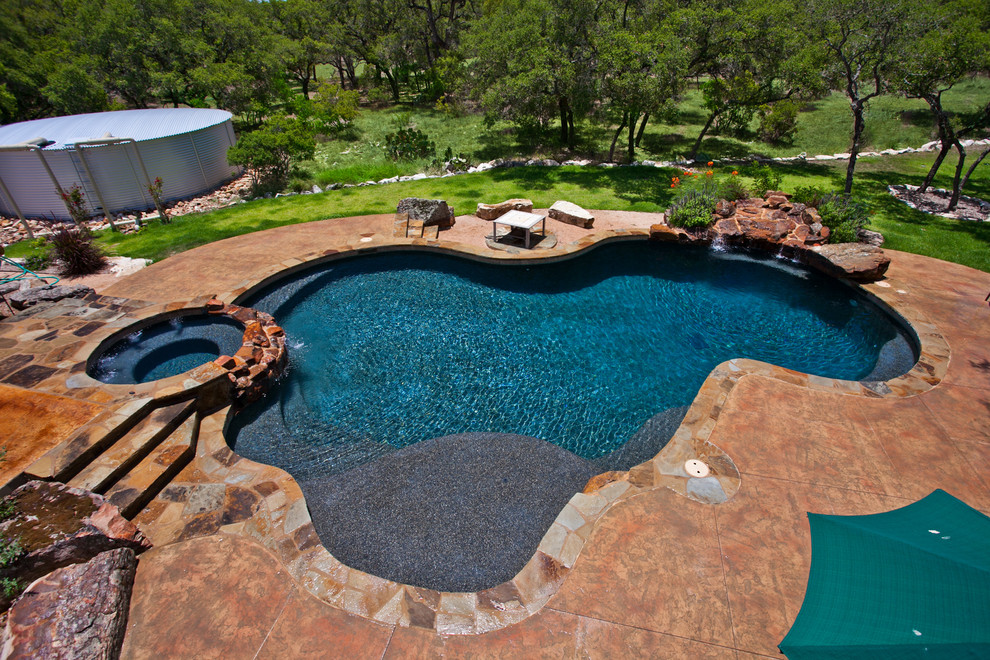 Inspiration pour une grande piscine naturelle et arrière chalet sur mesure avec un point d'eau et une dalle de béton.