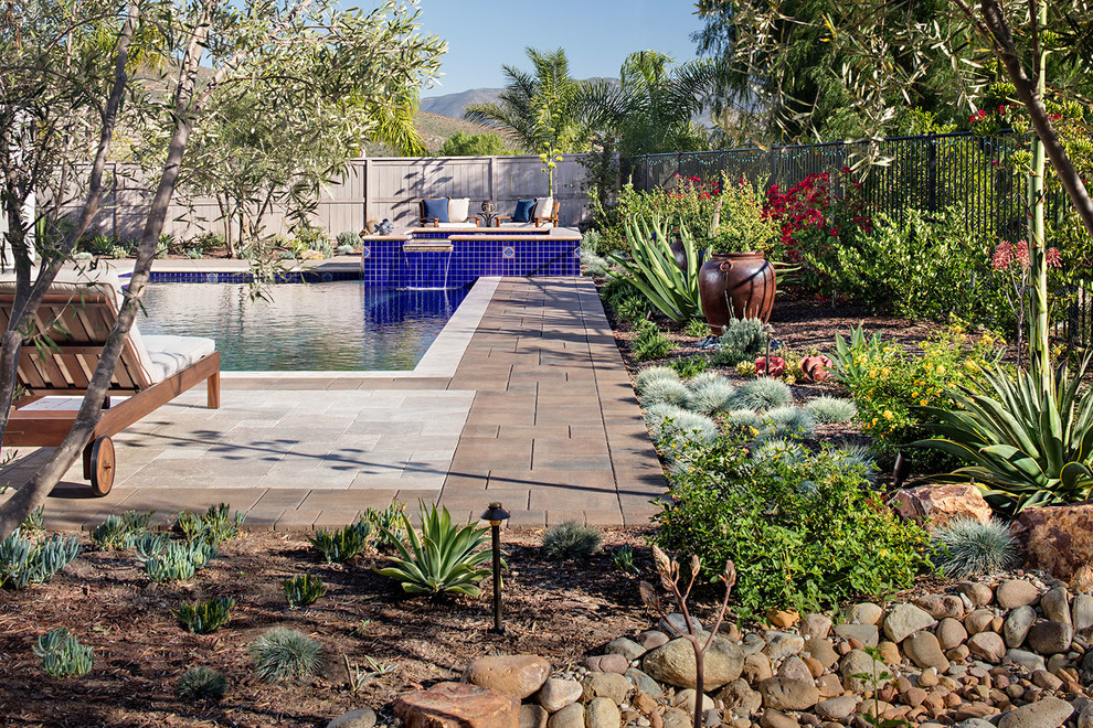Esempio di una piscina fuori terra mediterranea rettangolare di medie dimensioni e dietro casa con una vasca idromassaggio e pavimentazioni in pietra naturale