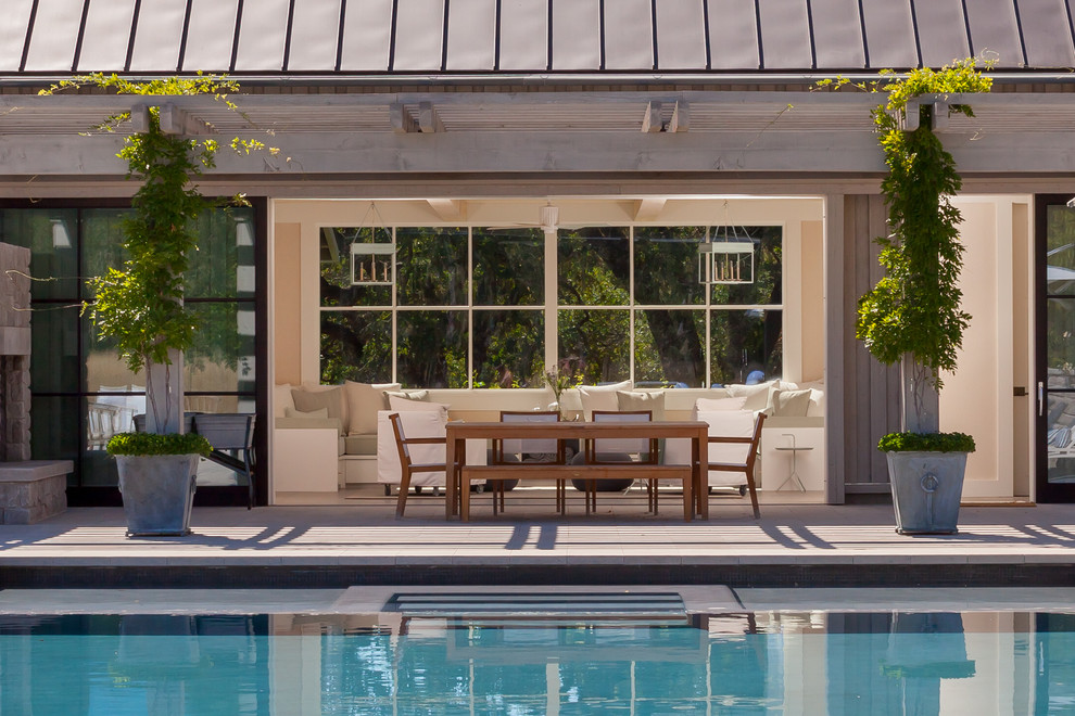 Ejemplo de piscina actual de tamaño medio rectangular en patio trasero con losas de hormigón