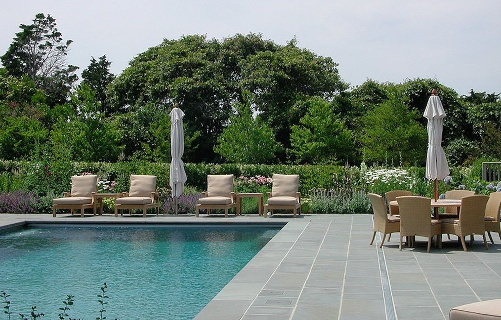 Ispirazione per una grande piscina monocorsia country rettangolare dietro casa con pavimentazioni in pietra naturale