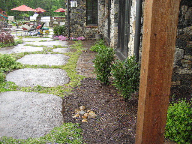 Modelo de jardín tropical grande en patio trasero con fuente y adoquines de piedra natural