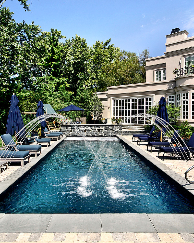 Ejemplo de piscina alargada mediterránea de tamaño medio rectangular en patio trasero con adoquines de hormigón