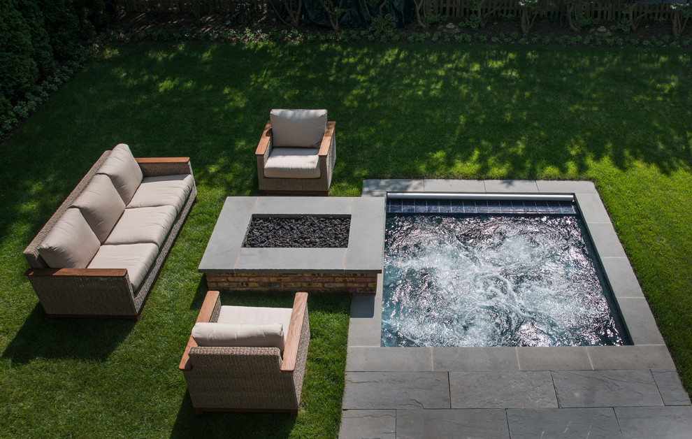 Cette image montre une petite piscine arrière traditionnelle rectangle avec un bain bouillonnant et des pavés en pierre naturelle.