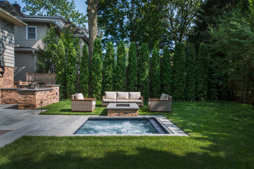 Diseño de piscinas y jacuzzis tradicionales pequeños rectangulares en patio trasero con adoquines de piedra natural