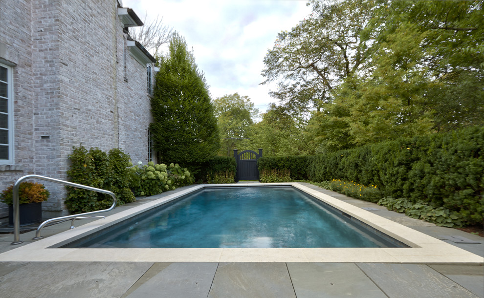 Inspiration for a small classic side rectangular lengths swimming pool in Chicago with natural stone paving.