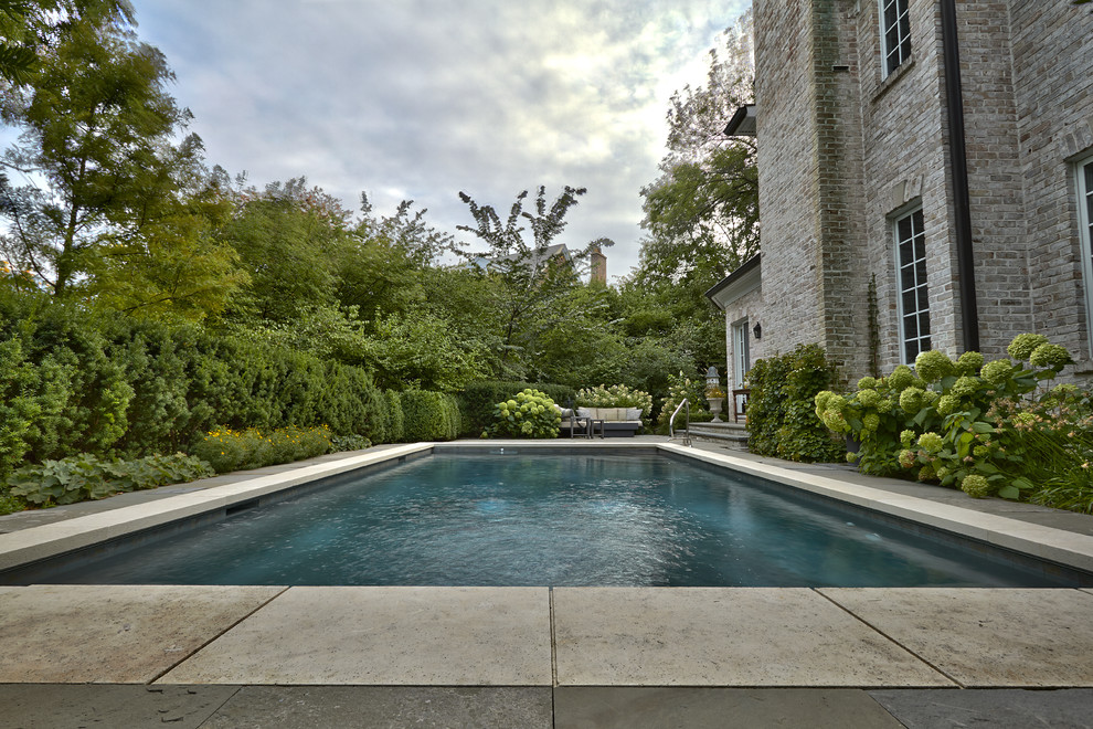Foto de piscina alargada tradicional pequeña rectangular en patio lateral con adoquines de piedra natural