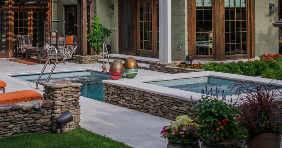 This is an example of a medium sized classic back rectangular lengths hot tub in Chicago with natural stone paving.