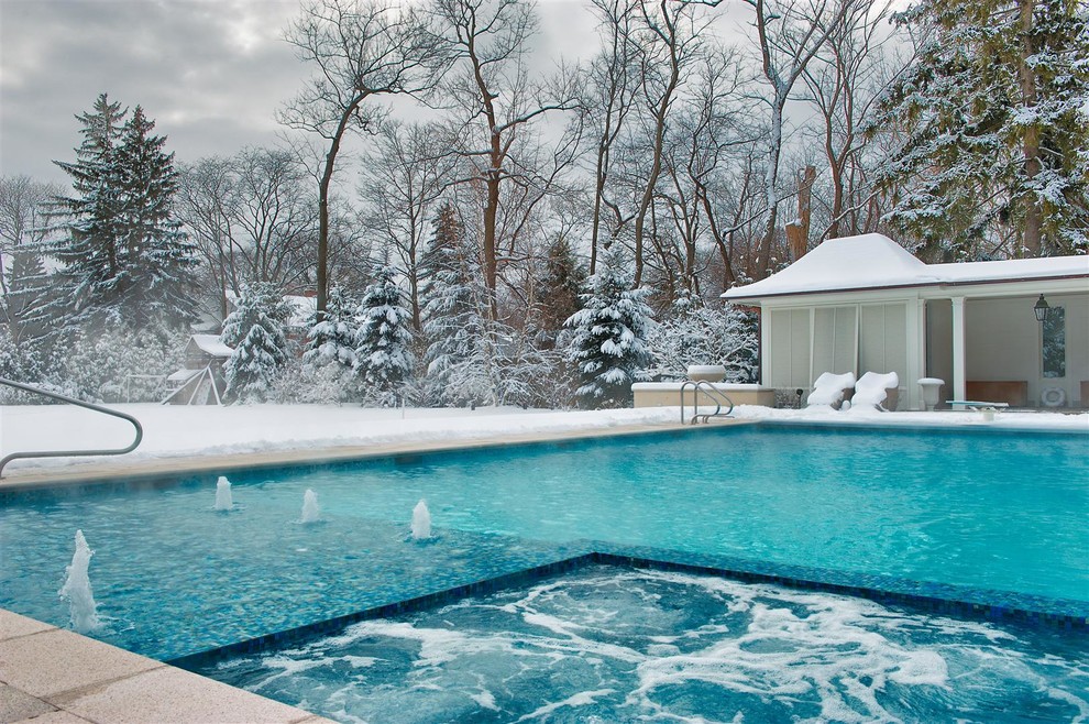 Foto de piscinas y jacuzzis alargados clásicos de tamaño medio rectangulares en patio trasero con adoquines de piedra natural