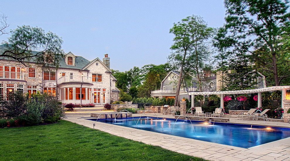 На фото: большой прямоугольный, спортивный бассейн на заднем дворе в классическом стиле с фонтаном и мощением тротуарной плиткой с