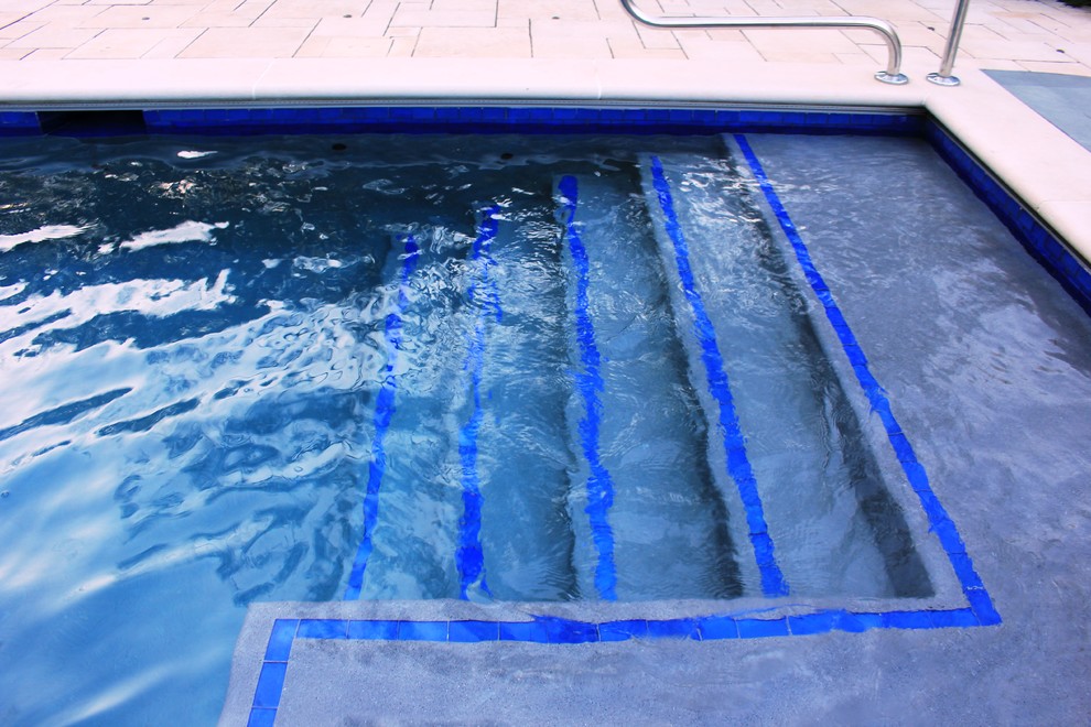 Aménagement d'une grande piscine arrière classique rectangle avec un point d'eau.