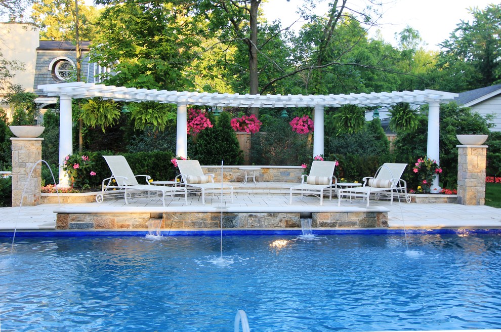 Foto di una grande piscina chic rettangolare dietro casa con fontane