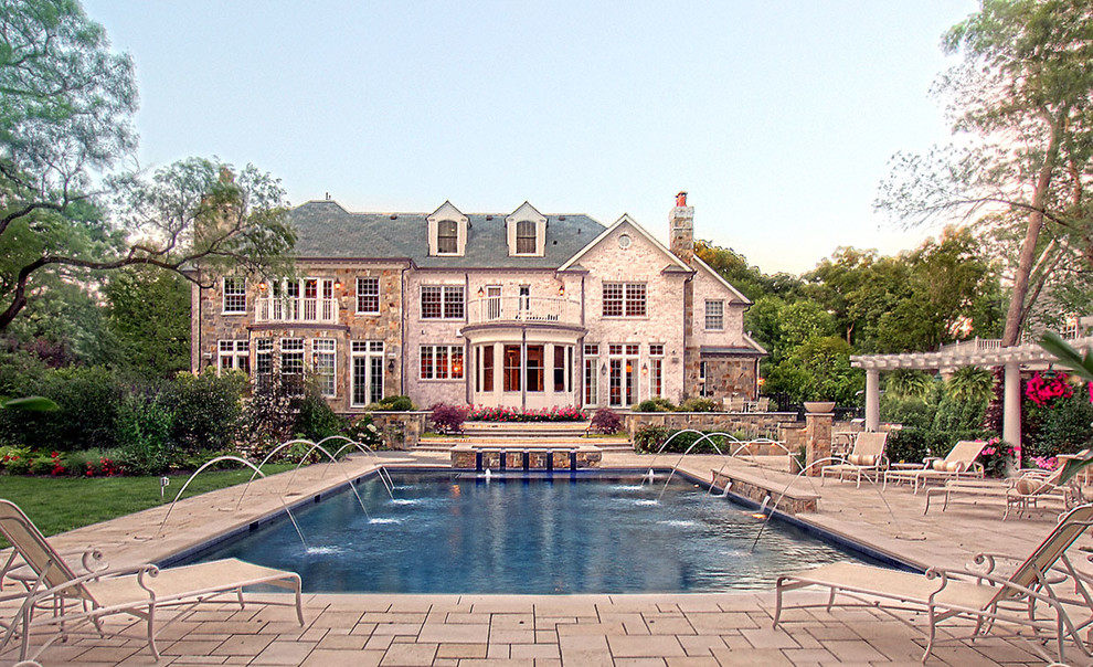 Foto de piscina con fuente alargada clásica grande rectangular en patio trasero con adoquines de hormigón
