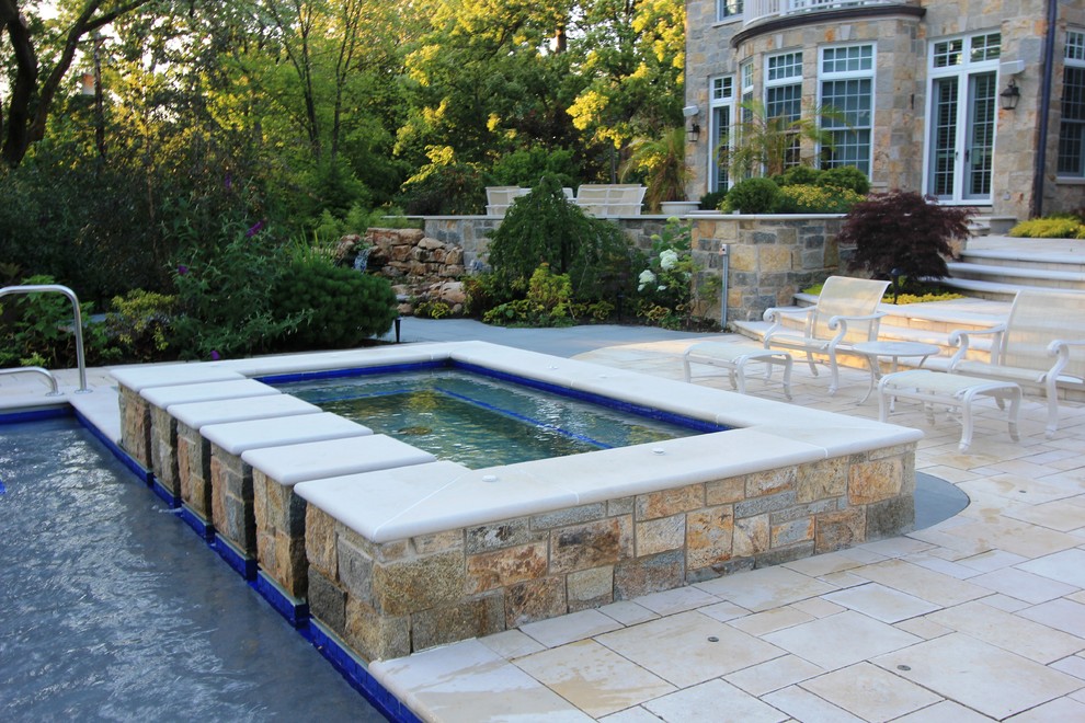 Immagine di una grande piscina chic rettangolare dietro casa con fontane