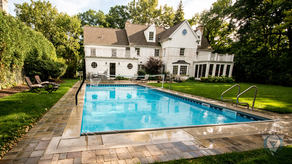 Foto de piscina con fuente natural tradicional de tamaño medio rectangular en patio trasero con adoquines de hormigón