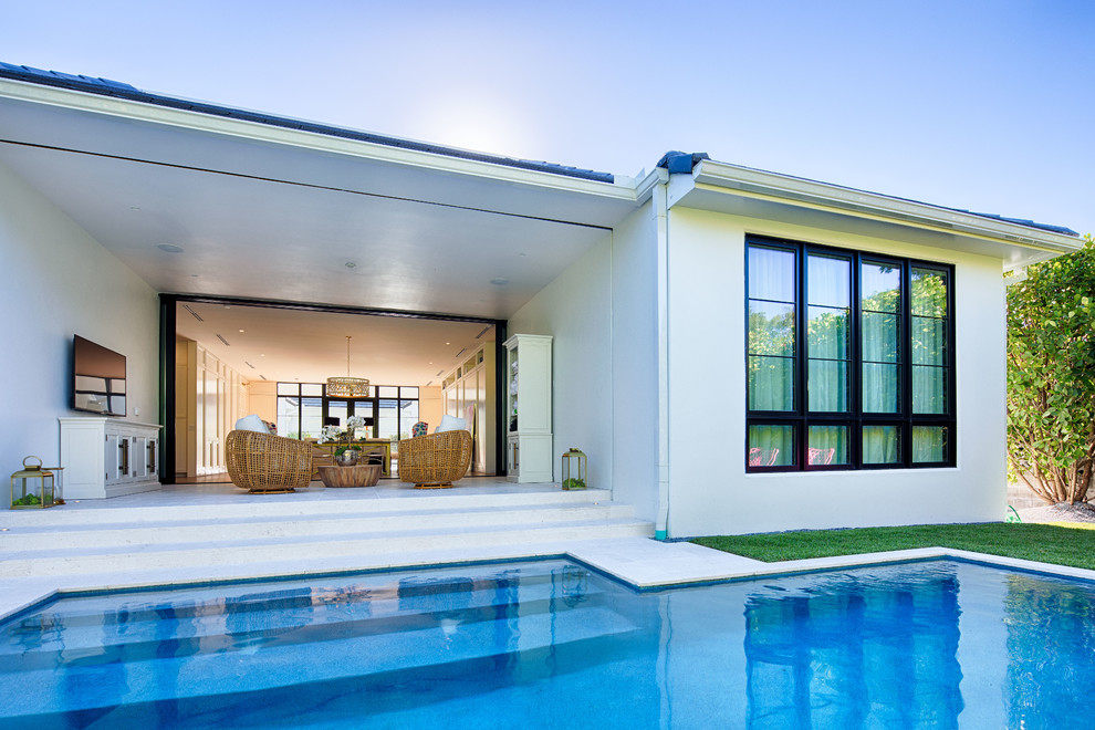 Idee per una piscina monocorsia minimal rettangolare di medie dimensioni e dietro casa con lastre di cemento