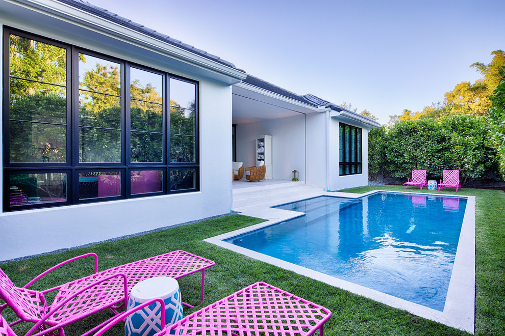 Diseño de piscina alargada contemporánea de tamaño medio rectangular en patio trasero con losas de hormigón