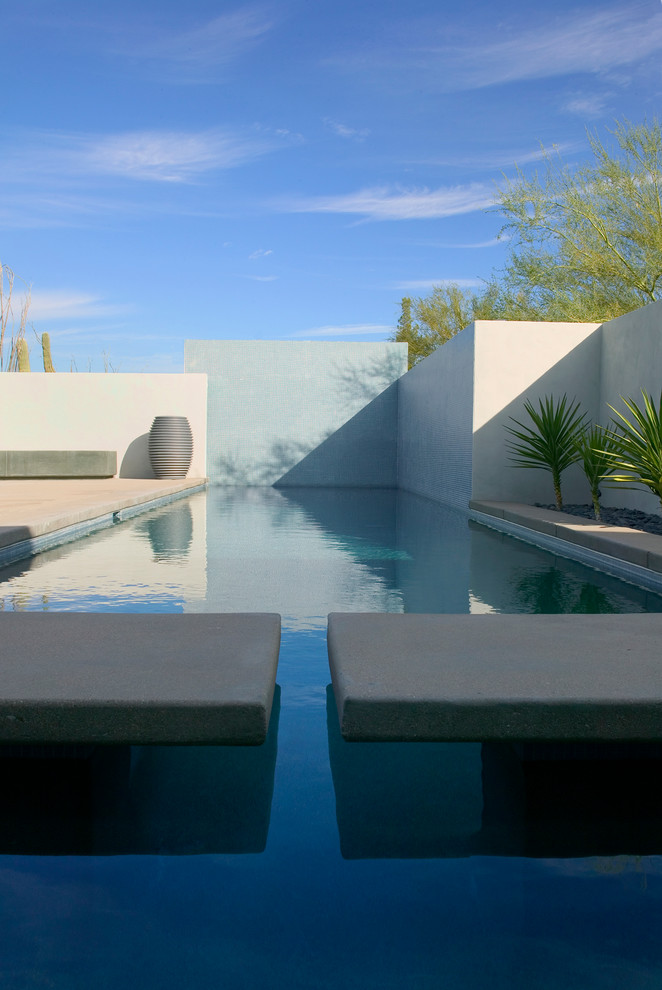 Идея дизайна: прямоугольный бассейн на внутреннем дворе в стиле модернизм с покрытием из бетонных плит