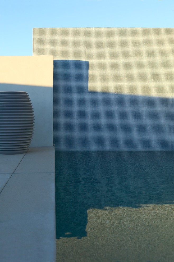 Diseño de piscina minimalista rectangular con losas de hormigón