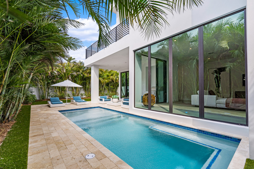 Moderner Pool in rechteckiger Form mit Natursteinplatten in Miami