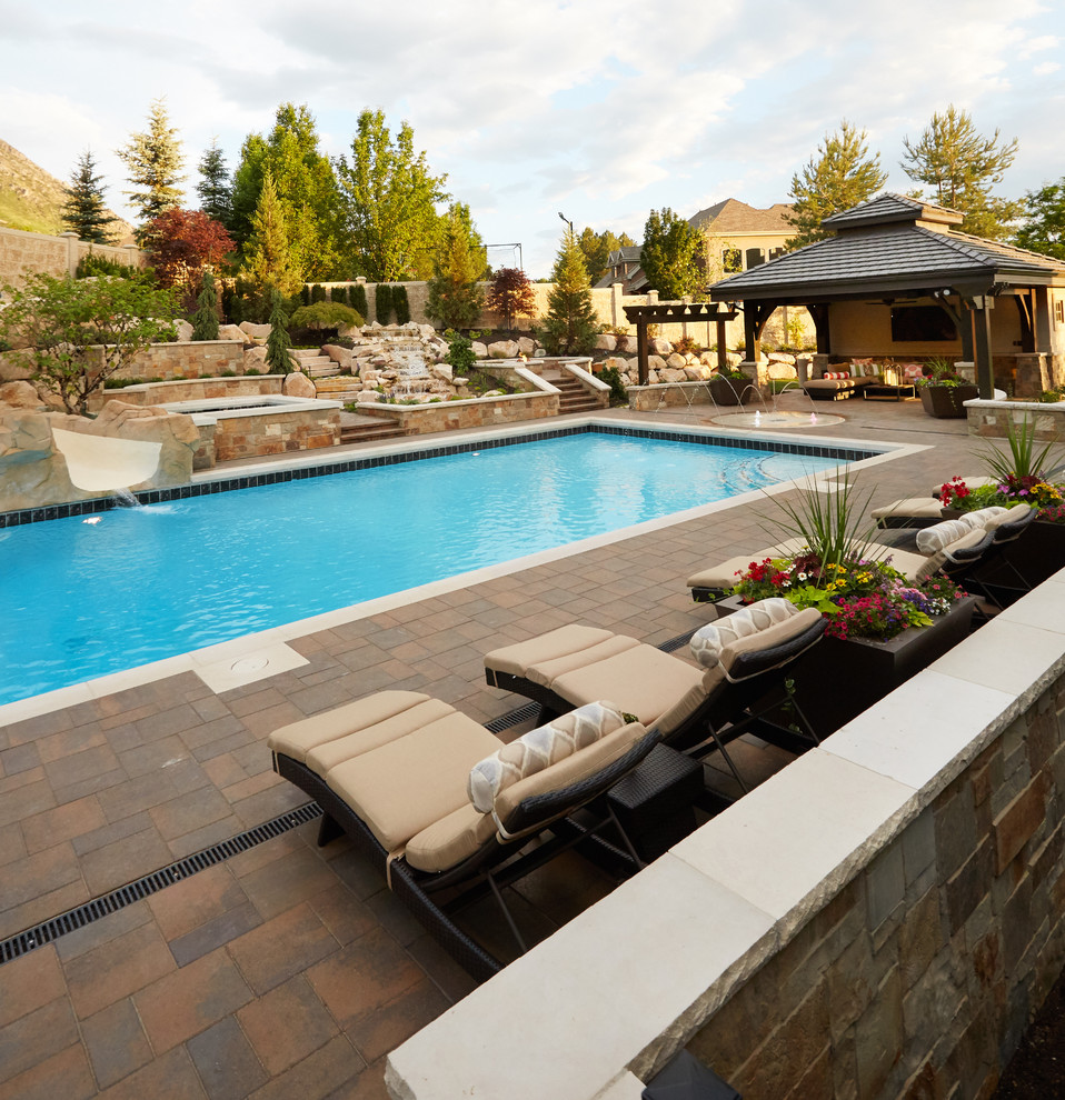 Imagen de piscina con tobogán alargada clásica renovada grande rectangular en patio trasero