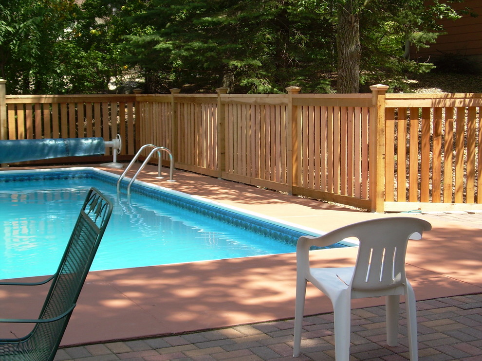 Пример оригинального дизайна: прямоугольный бассейн среднего размера на заднем дворе в стиле кантри с мощением клинкерной брусчаткой