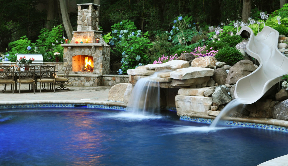 Esempio di una grande piscina monocorsia tradizionale personalizzata dietro casa con un acquascivolo