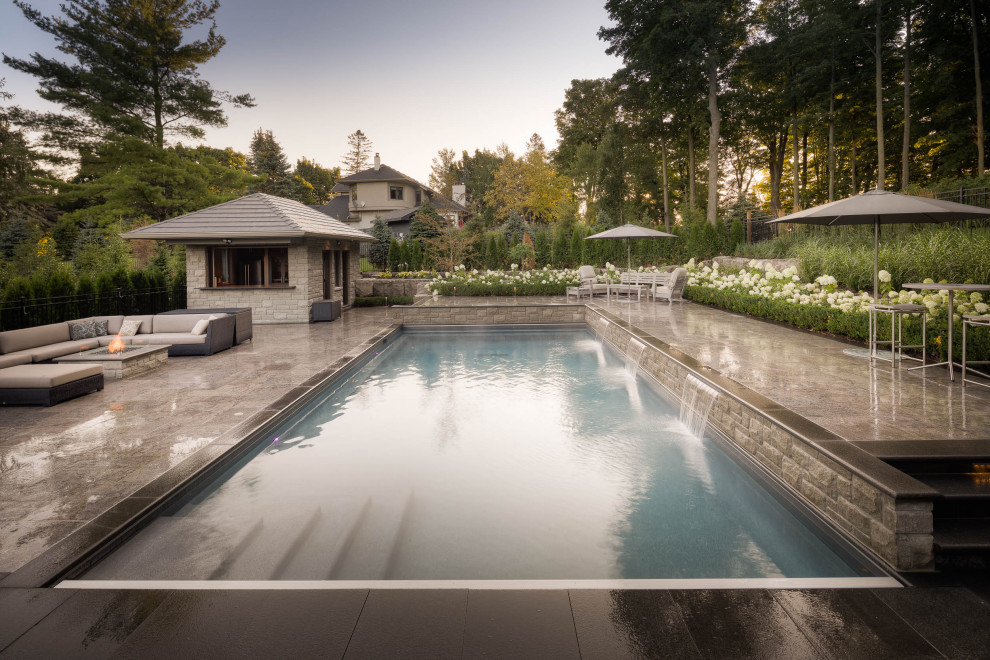 Großer Klassischer Pool hinter dem Haus in rechteckiger Form mit Natursteinplatten in Toronto