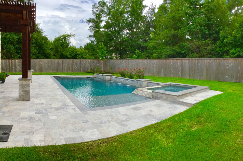 Modelo de piscinas y jacuzzis alargados actuales de tamaño medio rectangulares en patio trasero con adoquines de piedra natural