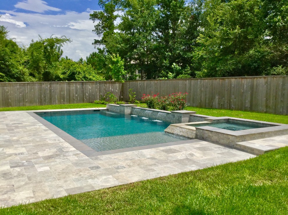 Foto de piscinas y jacuzzis alargados actuales de tamaño medio rectangulares en patio trasero con adoquines de piedra natural