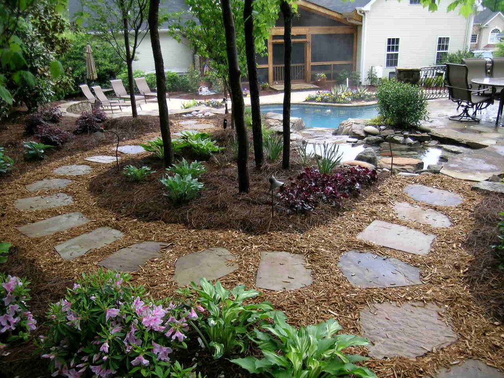 Ispirazione per una grande piscina naturale tradizionale personalizzata dietro casa con fontane e pavimentazioni in pietra naturale