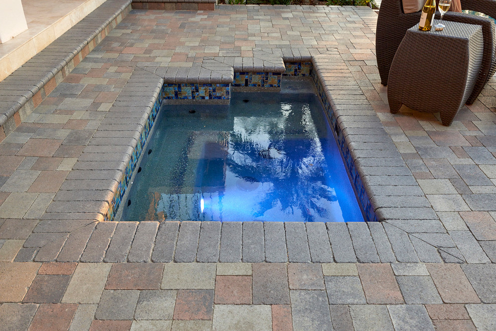 На фото: наземный, прямоугольный бассейн среднего размера на заднем дворе в современном стиле с мощением тротуарной плиткой
