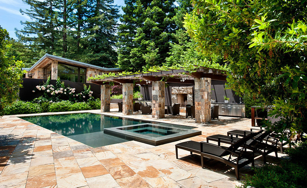 Aménagement d'une piscine à débordement contemporaine de taille moyenne et rectangle avec des pavés en pierre naturelle.
