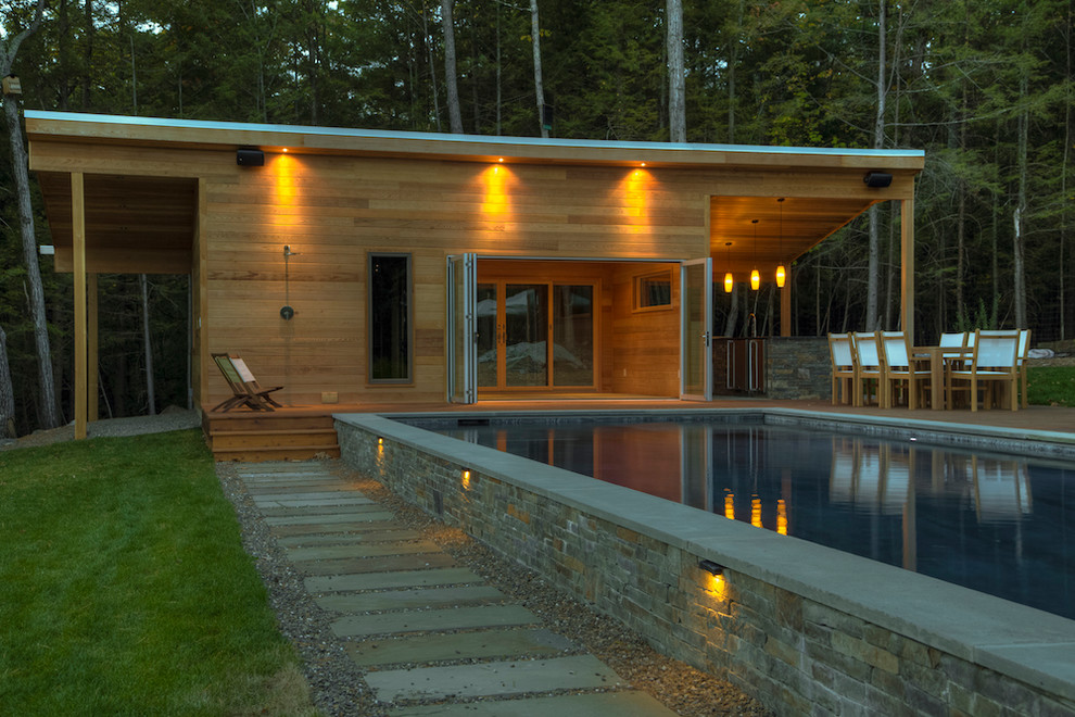 Aménagement d'une piscine latérale montagne rectangle et de taille moyenne avec une terrasse en bois.