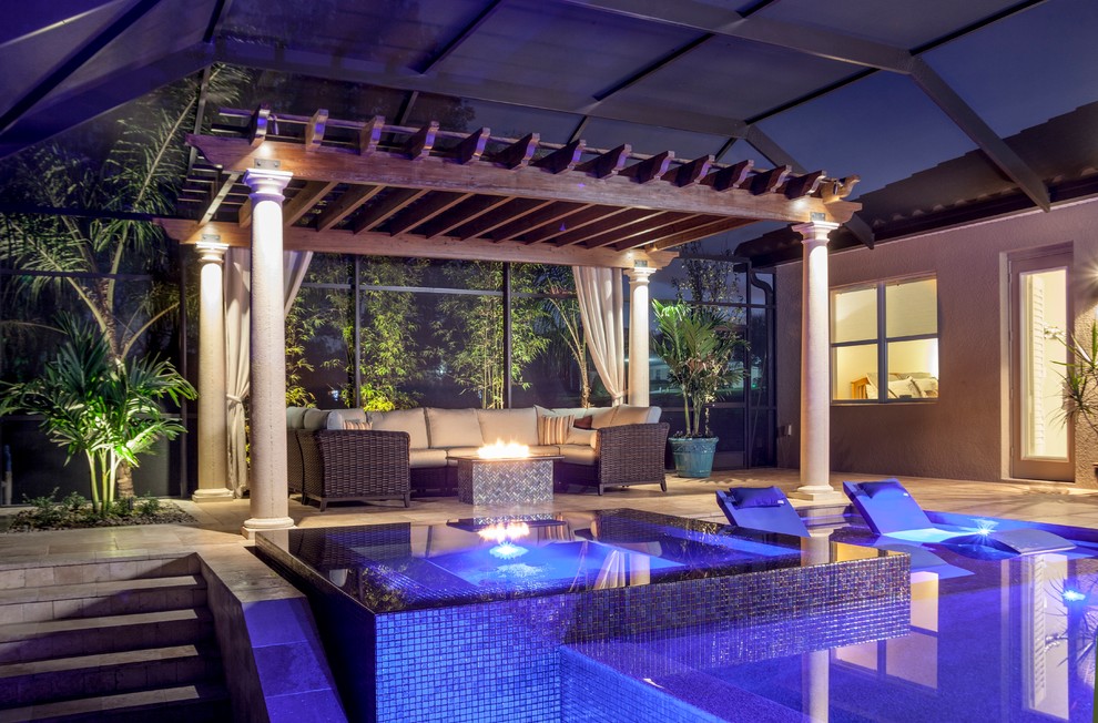 Diseño de piscina con fuente clásica renovada de tamaño medio a medida en patio trasero con adoquines de piedra natural