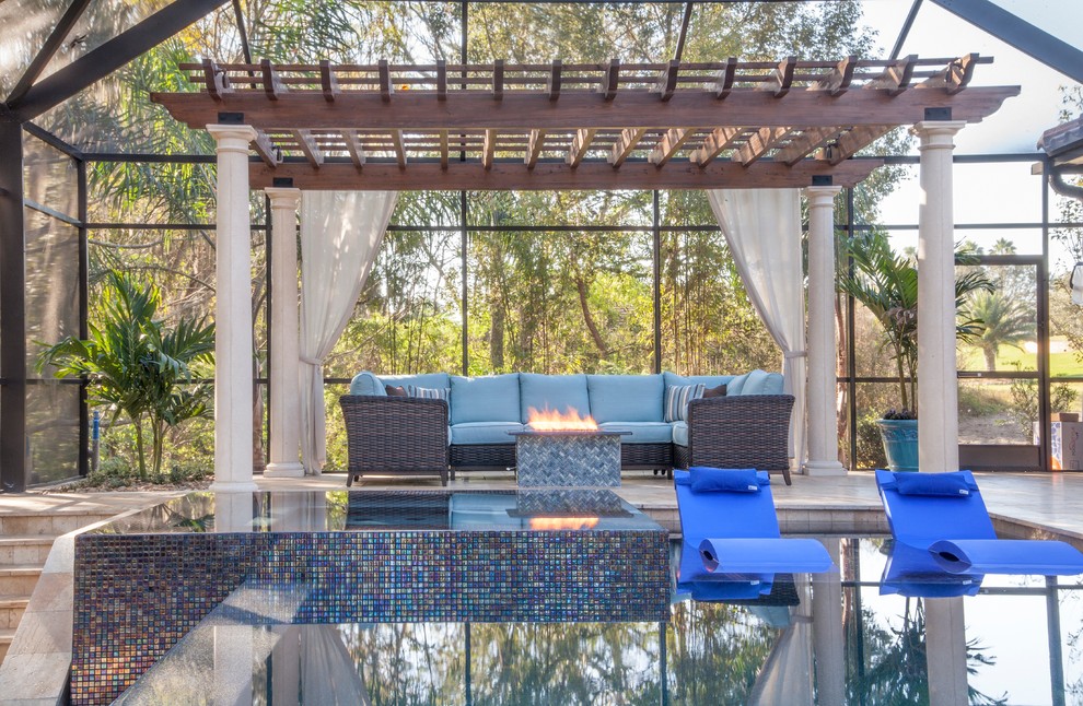 Ejemplo de piscina con fuente clásica renovada de tamaño medio a medida en patio trasero con adoquines de piedra natural