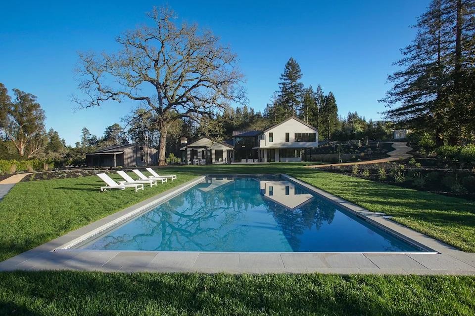 Imagen de piscina alargada minimalista grande rectangular en patio trasero con adoquines de hormigón