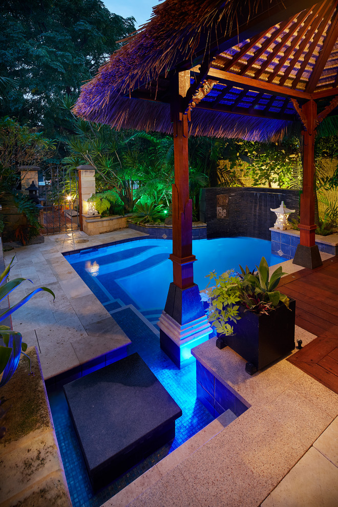 Foto de piscina con fuente exótica pequeña a medida en patio trasero con entablado