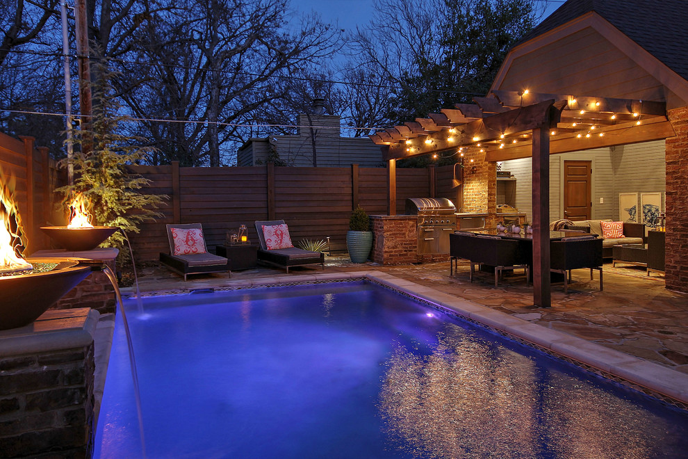 Imagen de piscina alargada actual de tamaño medio rectangular en patio trasero con adoquines de piedra natural