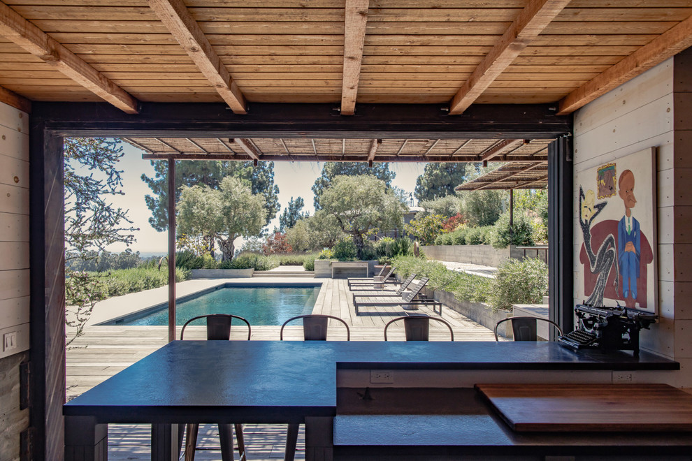 Pool house - contemporary backyard rectangular pool house idea in Santa Barbara with decking