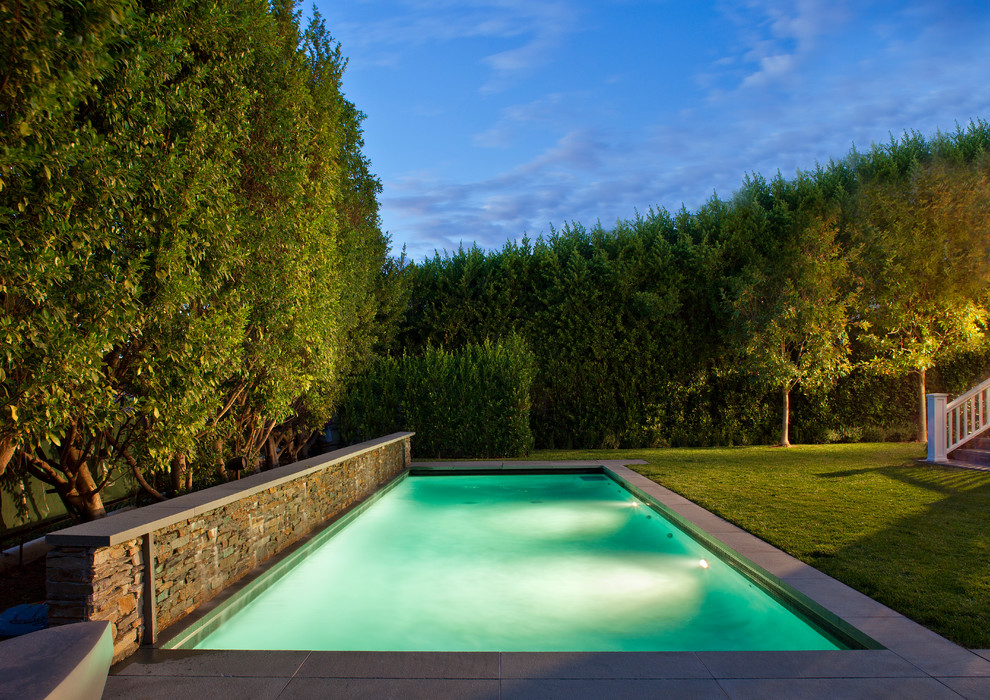 Diseño de piscinas y jacuzzis alargados clásicos renovados de tamaño medio rectangulares en patio trasero con adoquines de hormigón