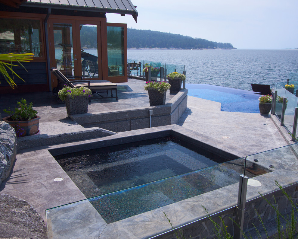 Cette image montre une piscine à débordement et arrière design sur mesure avec un bain bouillonnant.