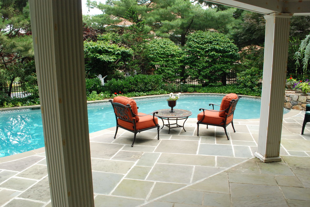 Cette image montre une piscine naturelle et arrière traditionnelle en forme de haricot de taille moyenne avec des pavés en pierre naturelle.