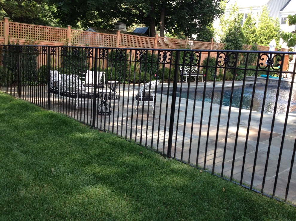 Aménagement d'une grande piscine arrière classique rectangle avec un point d'eau et une dalle de béton.