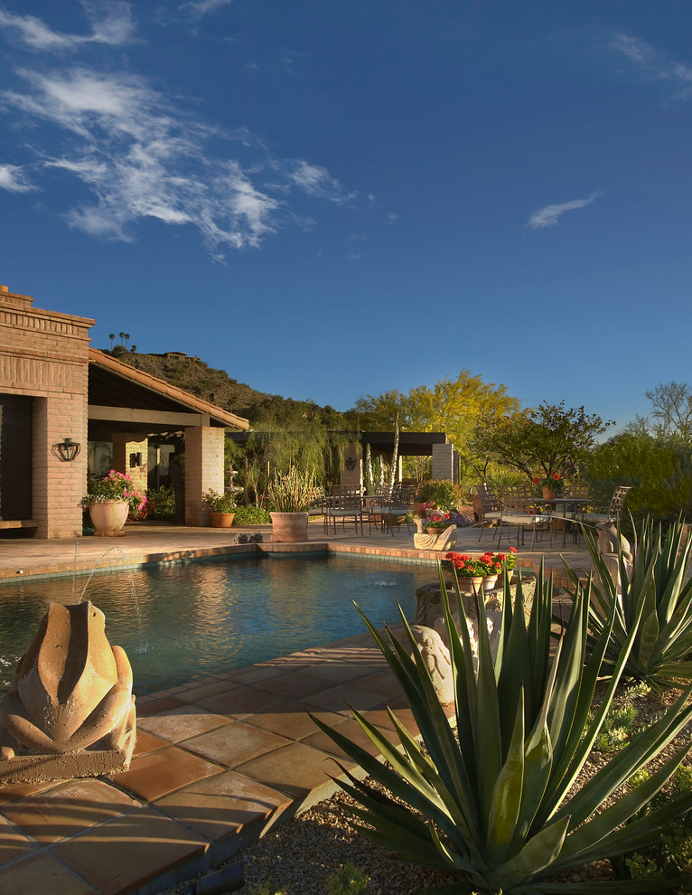 Ejemplo de piscina de estilo americano rectangular con adoquines de piedra natural