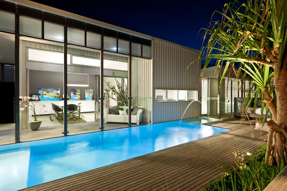Modernes Sportbecken hinter dem Haus in individueller Form mit Dielen und Wasserspiel in Brisbane