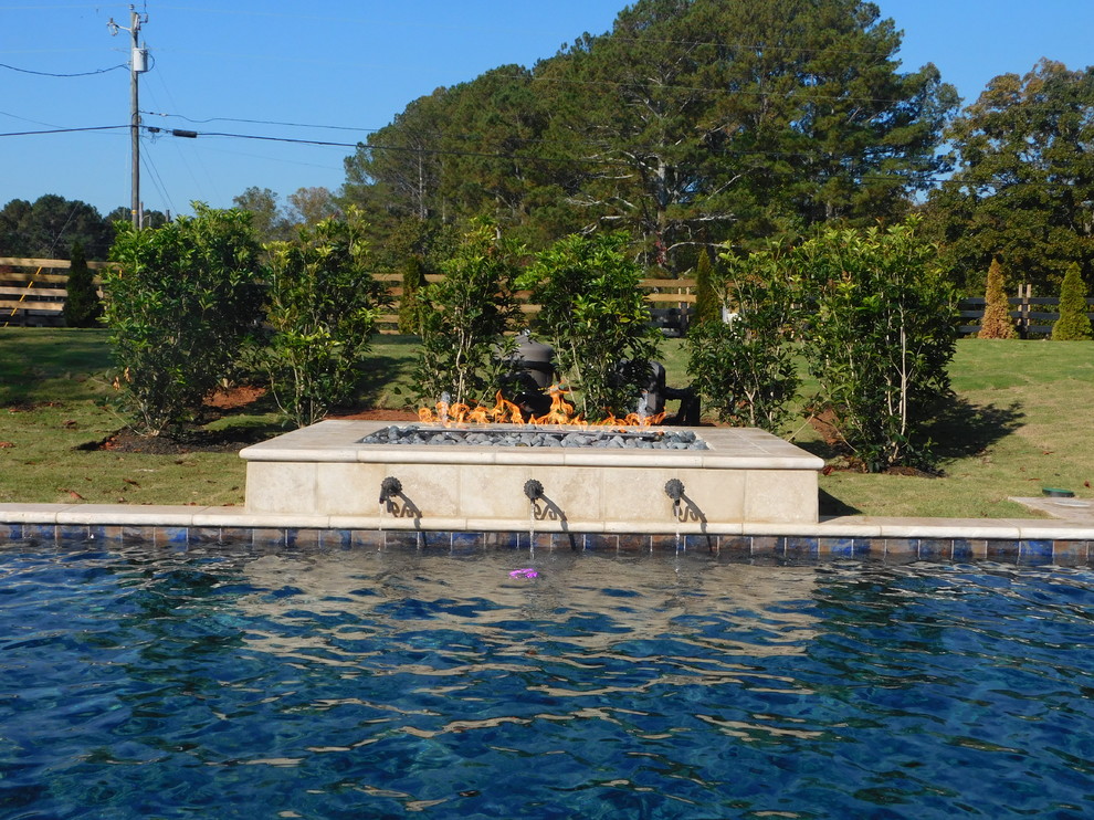 На фото: прямоугольный бассейн среднего размера на заднем дворе в средиземноморском стиле с фонтаном и покрытием из каменной брусчатки